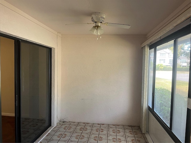 unfurnished sunroom with ceiling fan