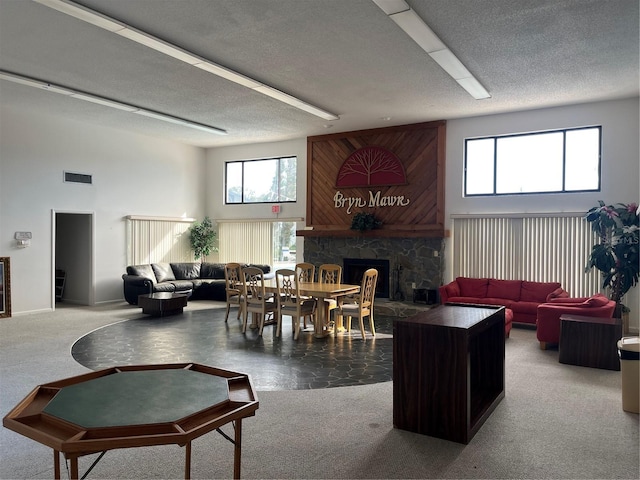 living room with a textured ceiling, carpet floors, and a wealth of natural light