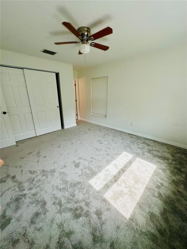 unfurnished bedroom featuring ceiling fan, a closet, and carpet floors