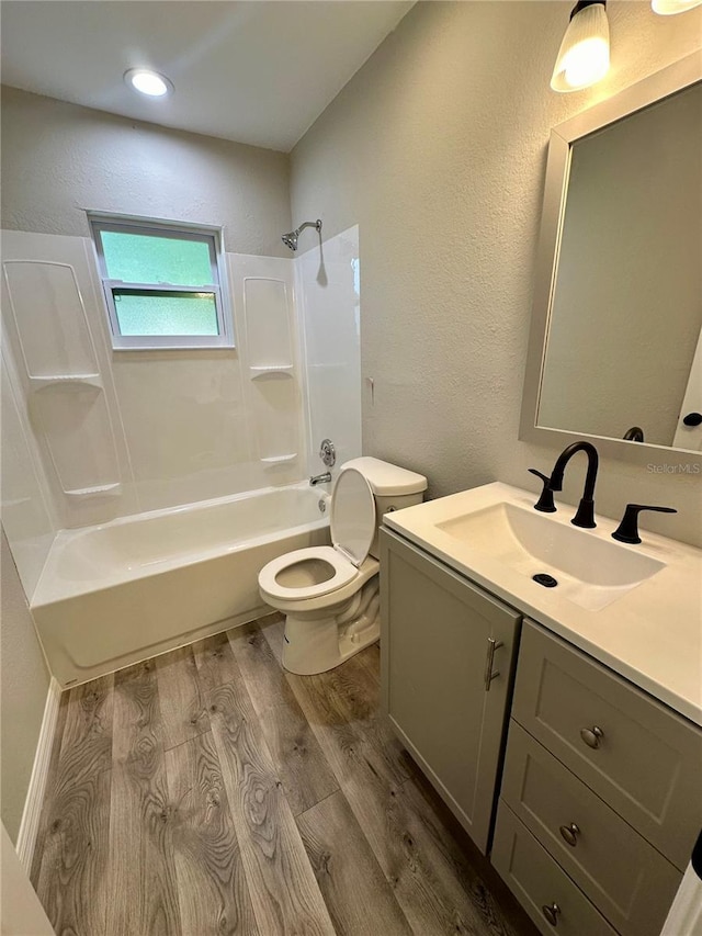 full bathroom featuring shower / washtub combination, hardwood / wood-style floors, vanity, and toilet