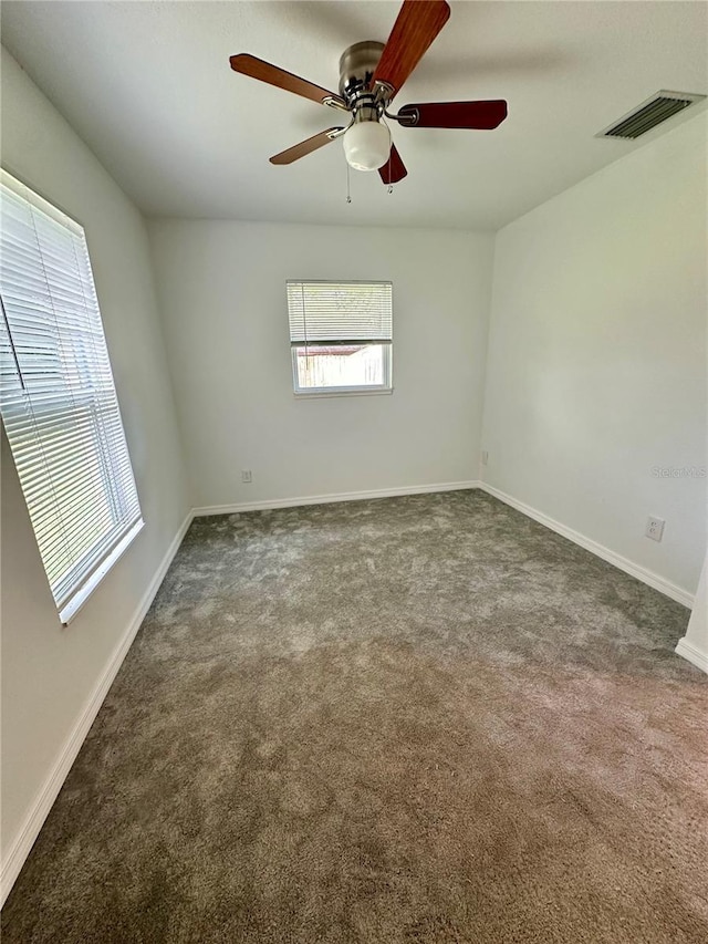 unfurnished room featuring ceiling fan and dark carpet