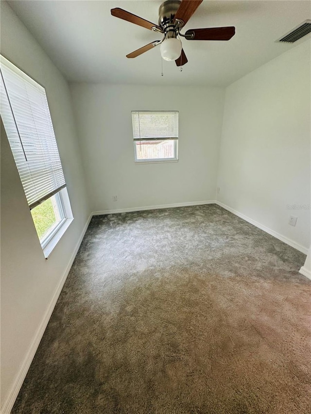 carpeted empty room featuring ceiling fan and a healthy amount of sunlight