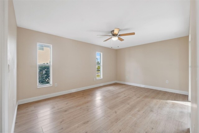 spare room with ceiling fan, a healthy amount of sunlight, and light hardwood / wood-style floors