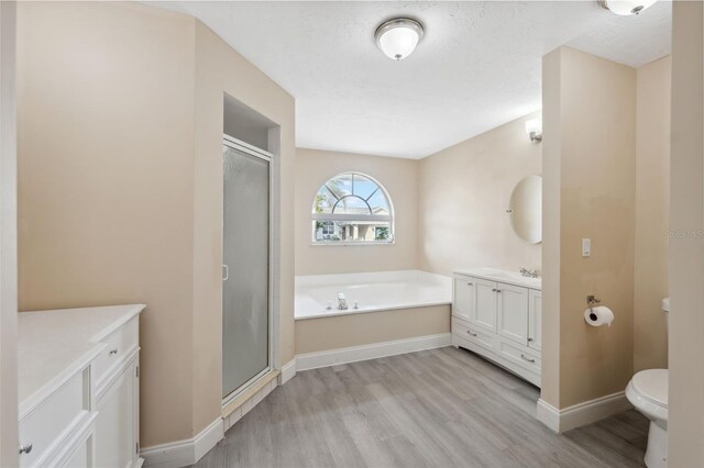 full bathroom featuring vanity, hardwood / wood-style flooring, toilet, and separate shower and tub