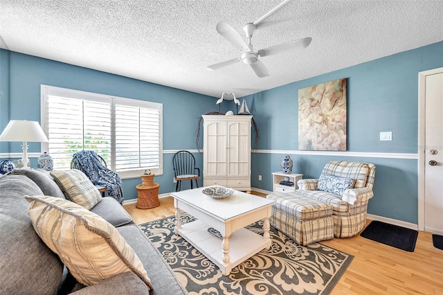 living room featuring a textured ceiling, light hardwood / wood-style flooring, and ceiling fan