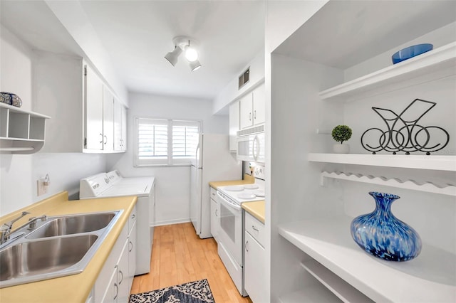 kitchen featuring white appliances, sink, separate washer and dryer, light hardwood / wood-style floors, and white cabinetry