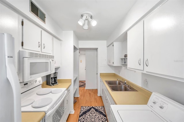 kitchen featuring sink, white cabinets, white appliances, and washer / dryer