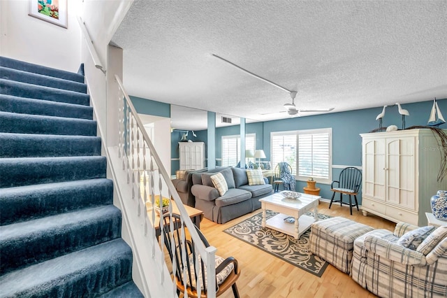 living room with ceiling fan, hardwood / wood-style floors, and a textured ceiling