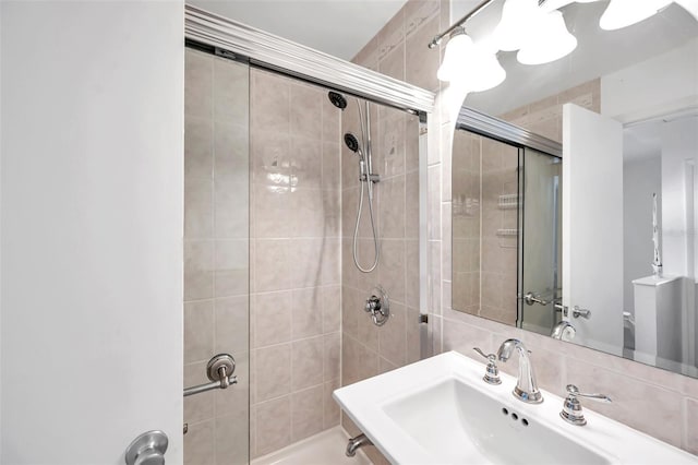 bathroom with decorative backsplash, sink, and walk in shower