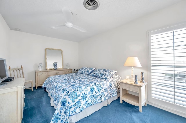 carpeted bedroom featuring a textured ceiling, multiple windows, and ceiling fan