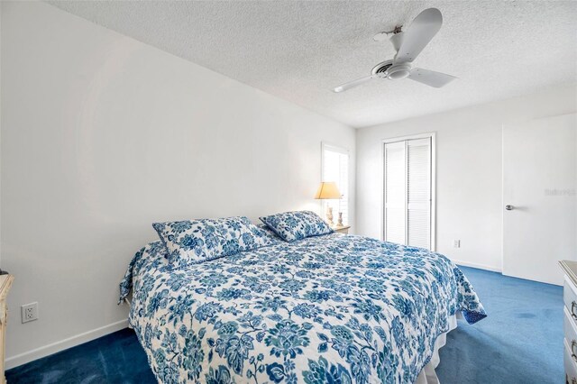 carpeted bedroom with ceiling fan, a closet, and a textured ceiling