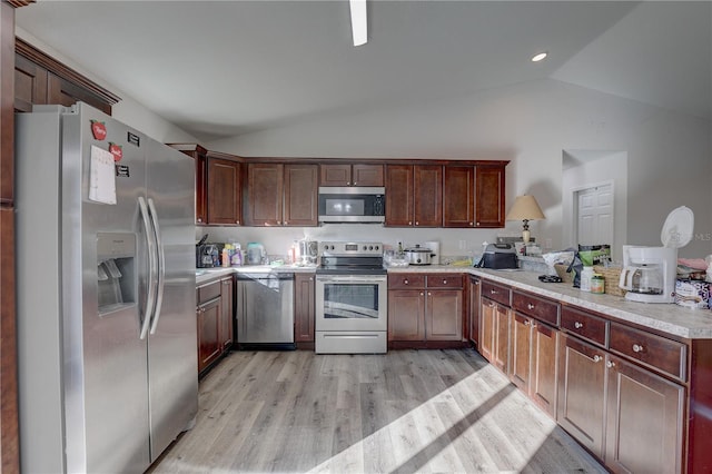 kitchen featuring appliances with stainless steel finishes, light hardwood / wood-style floors, and vaulted ceiling
