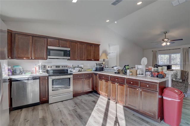 kitchen featuring kitchen peninsula, light hardwood / wood-style floors, lofted ceiling, and stainless steel appliances