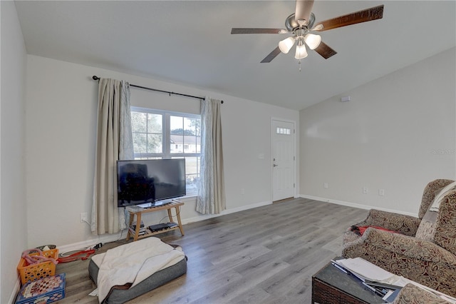 living room featuring light wood-type flooring, vaulted ceiling, and ceiling fan
