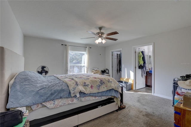 carpeted bedroom with ceiling fan and ensuite bath