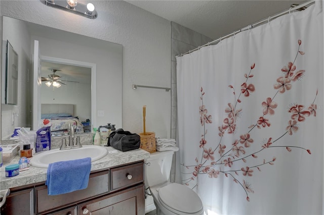 bathroom featuring vanity, a shower with shower curtain, ceiling fan, toilet, and a textured ceiling
