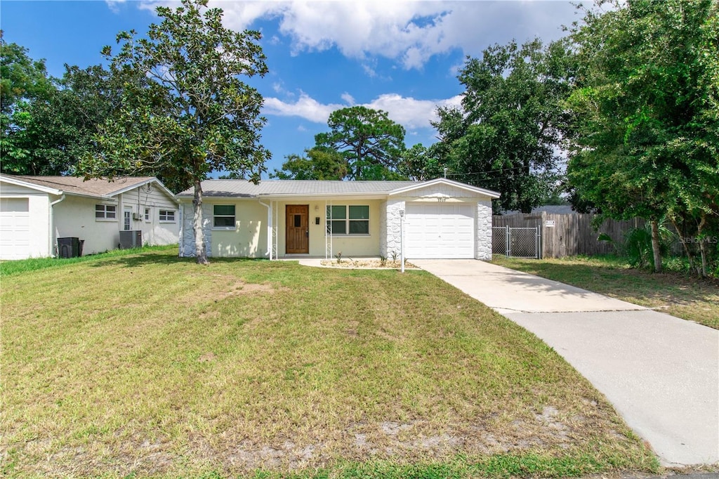 single story home with a porch, a garage, a front lawn, and central air condition unit