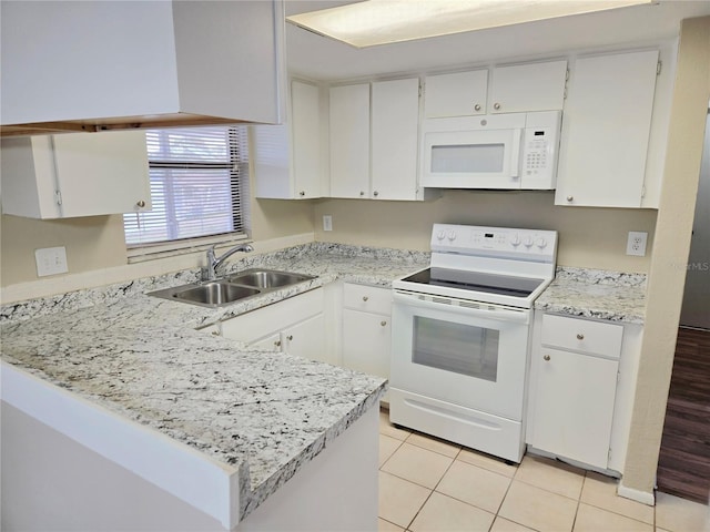 kitchen with white appliances, white cabinets, sink, light tile patterned flooring, and kitchen peninsula