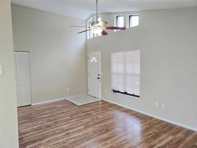 entryway featuring ceiling fan, light hardwood / wood-style flooring, and a high ceiling