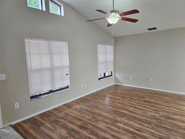 spare room with hardwood / wood-style flooring, ceiling fan, and high vaulted ceiling