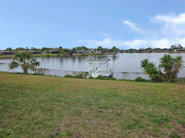 view of dock with a yard and a water view