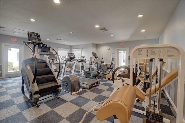 workout area featuring a textured ceiling and carpet floors