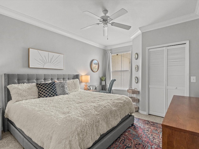 carpeted bedroom with baseboards, ornamental molding, ceiling fan, and a closet