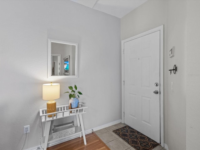 foyer with baseboards and tile patterned floors