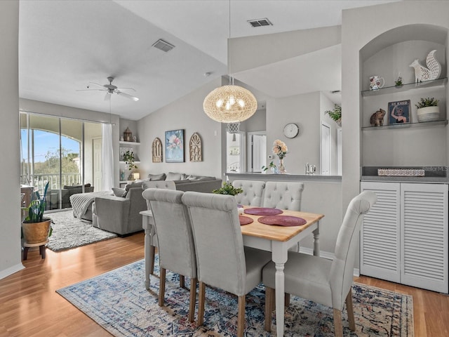 dining area with built in shelves, visible vents, and wood finished floors