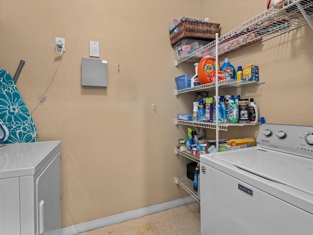 laundry room featuring laundry area, separate washer and dryer, tile patterned floors, and baseboards