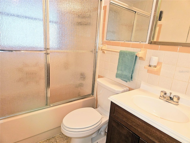 full bathroom with toilet, tasteful backsplash, tile walls, vanity, and enclosed tub / shower combo