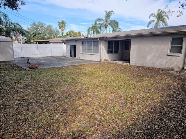 back of property with a patio and a lawn