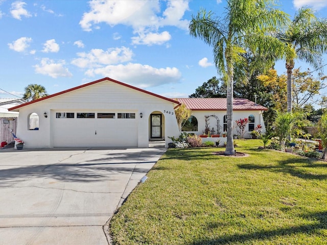 mediterranean / spanish home featuring a front yard and a garage