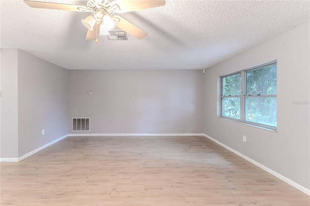 unfurnished room with a textured ceiling, light wood-type flooring, and ceiling fan