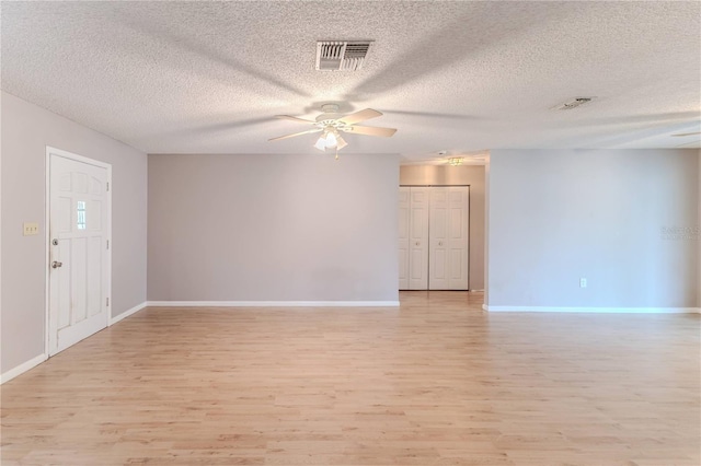 spare room featuring ceiling fan, light hardwood / wood-style floors, and a textured ceiling