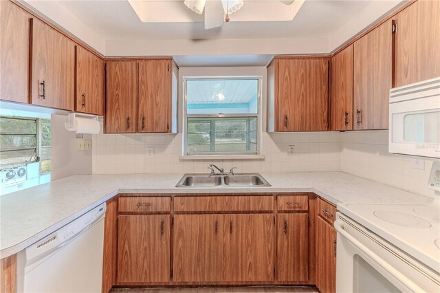 kitchen featuring kitchen peninsula, ceiling fan, white appliances, and sink