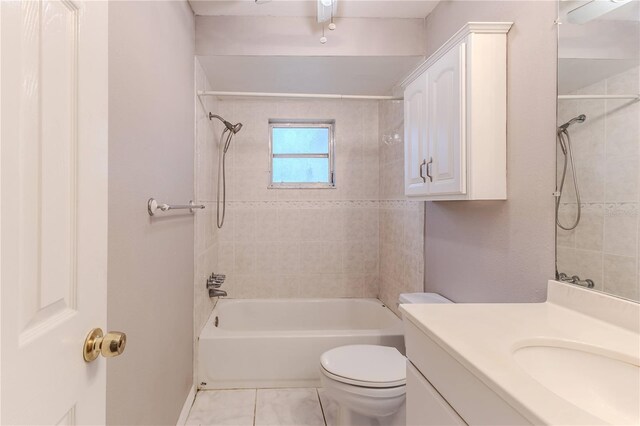 full bathroom featuring vanity, tile patterned floors, tiled shower / bath combo, and toilet