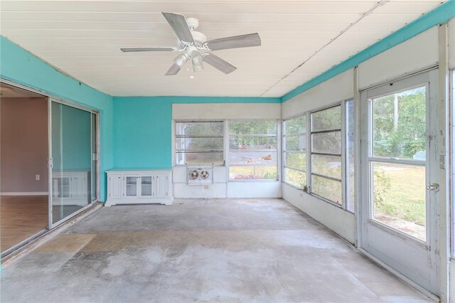 unfurnished sunroom featuring ceiling fan and a healthy amount of sunlight