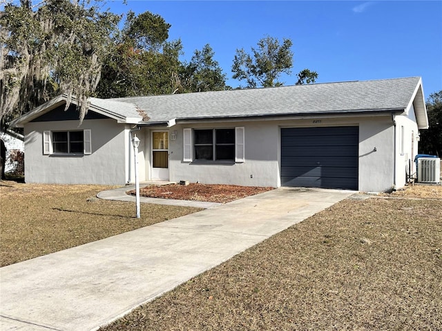 ranch-style home with a garage and central AC