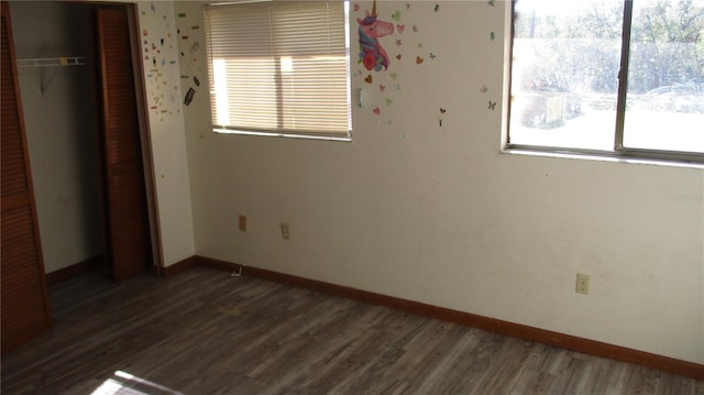 unfurnished bedroom with dark hardwood / wood-style floors and a closet