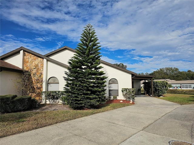 9163 Lingrove Rd, Weeki Wachee, FL 34613 - view of side of property with stucco siding, stone siding, and driveway