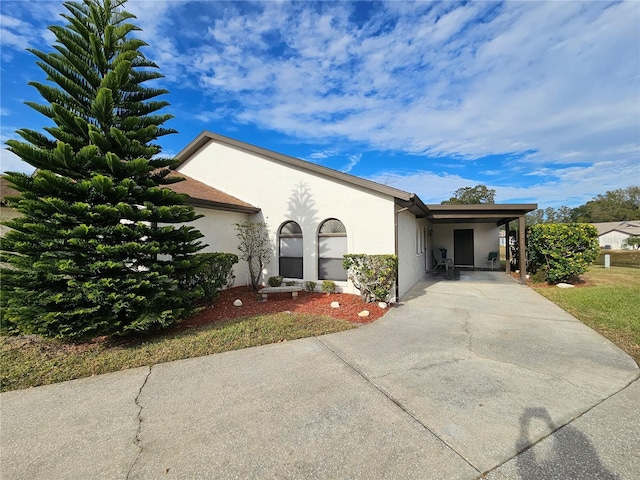 9163 Lingrove Rd, Weeki Wachee, FL 34613 - view of front of home with stucco siding, concrete driveway, and a carport