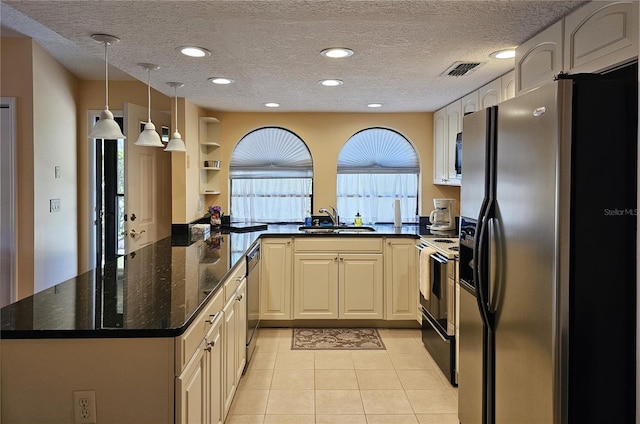 kitchen with sink, light tile patterned floors, appliances with stainless steel finishes, decorative light fixtures, and kitchen peninsula