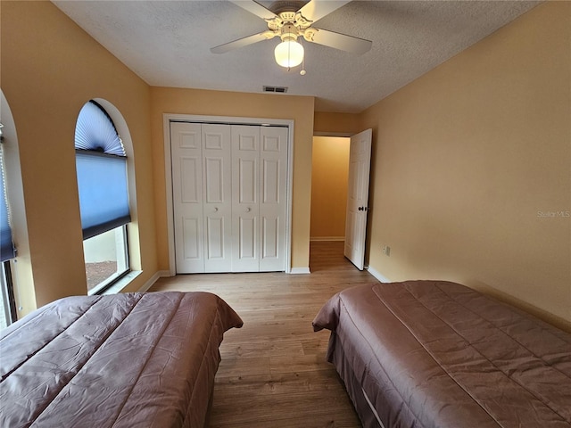 9163 Lingrove Rd, Weeki Wachee, FL 34613 - bedroom featuring light wood finished floors, a textured ceiling, a closet, and ceiling fan