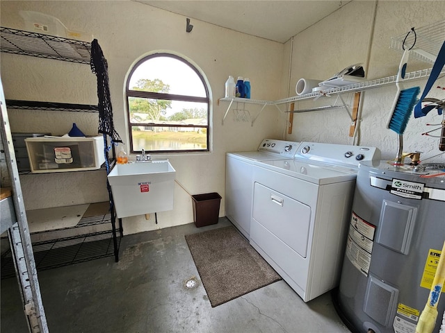 laundry room featuring electric water heater, washer and clothes dryer, and sink