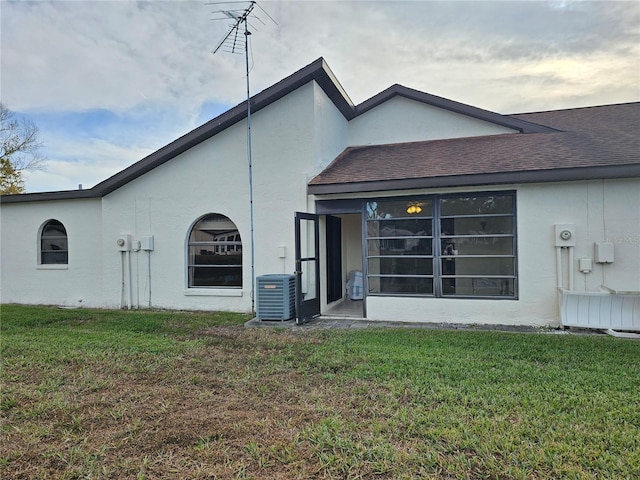 9163 Lingrove Rd, Weeki Wachee, FL 34613 - rear view of property with a yard, stucco siding, and roof with shingles