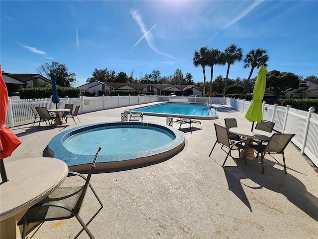 9163 Lingrove Rd, Weeki Wachee, FL 34613 - community pool with a patio, a fenced backyard, a community hot tub, and outdoor dining area