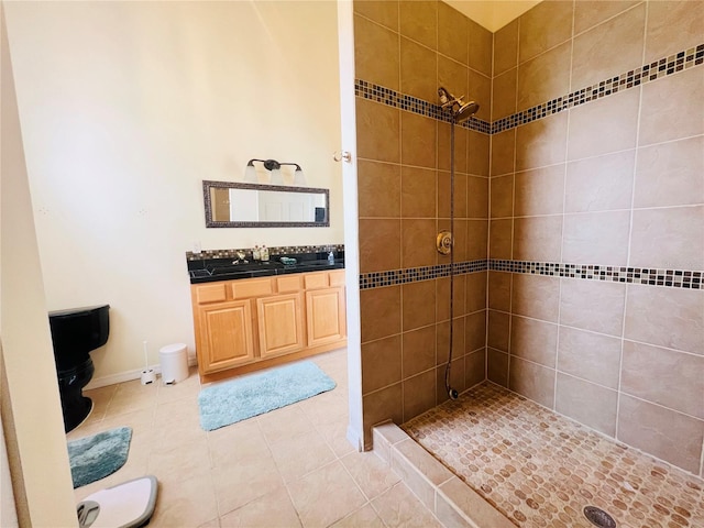 bathroom featuring a tile shower, tile patterned flooring, and vanity