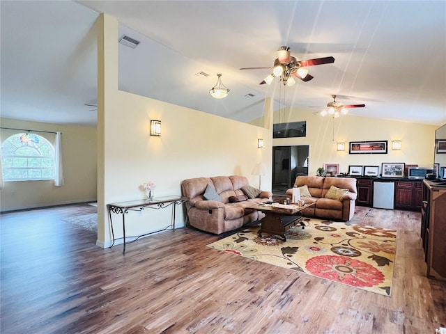 living room featuring hardwood / wood-style floors, ceiling fan, and vaulted ceiling