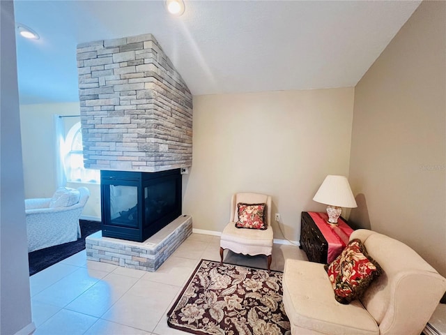 living room with a fireplace, vaulted ceiling, and light tile patterned flooring